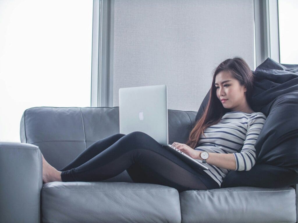 woman on the sofa with a computer - telehealth at urgent care
