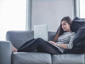 woman on the sofa with a computer - telehealth at urgent care